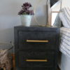 black and gold bedside table with lamp and plant